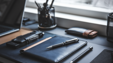 The image showcases a stylish and minimalist workspace with a high-quality mechanical pencil, leather wallet, multitool, and commuter bag arranged on a sleek desk, set against an urban American backdrop, exuding sophistication and practicality through a modern, masculine color palette of deep blues, grays, and metallic accents, all illuminated to evoke creativity and productivity